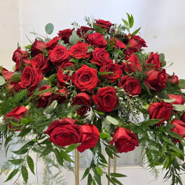 Large arrangement of red roses with greenery on a stand