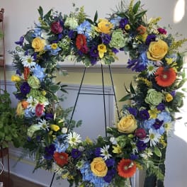 Large floral wreath on an easel with multicolored flowers