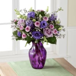 Purple and pink bouquet in a purple glass vase