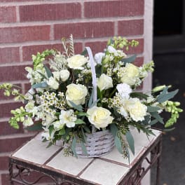White rose and carnation arrangement in a white basket