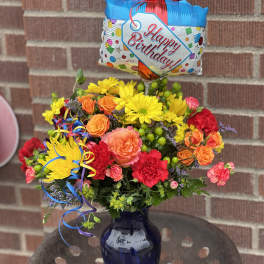 Birthday bouquet in a blue vase with a balloon topper
