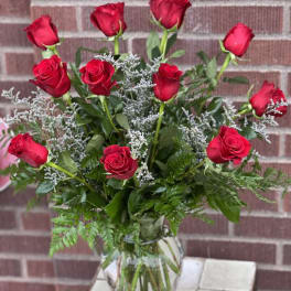Red roses arranged in a clear glass vase