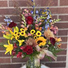 Mixed bouquet in a glass vase with red roses and yellow sunflowers
