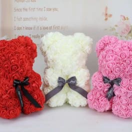 Three teddy bears made of roses in red, white, and pink with ribbons