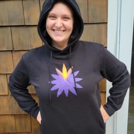 Person wearing a black hoodie with a purple and yellow flower graphic