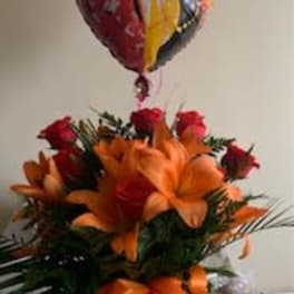 Bouquet of orange lilies and red roses with a heart-shaped balloon above