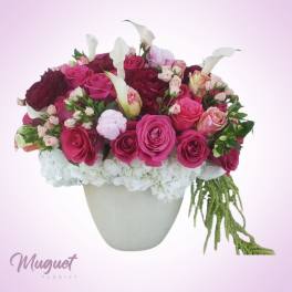 Pink and white rose arrangement in a white vase