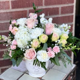 Pink and white rose bouquet in a white ceramic vase