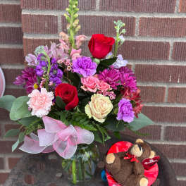 Mixed bouquet in a glass vase with a teddy bear gift