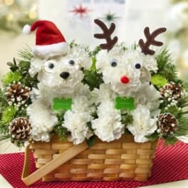 Basket arrangement with two white floral teddy bears in Santa and reindeer hats