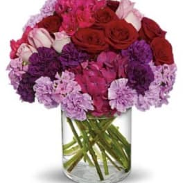 Bouquet of red and pink flowers in a clear glass vase