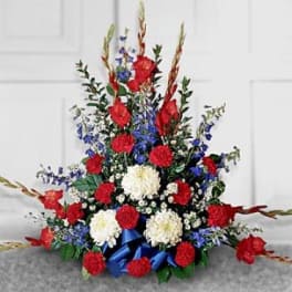 Red, white, and blue floral spray with ribbon accents