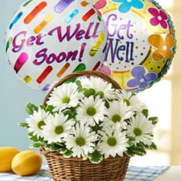 White daisies in a wicker basket with two get-well balloons