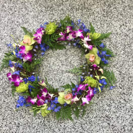 Circular floral wreath with purple orchids and blue flowers