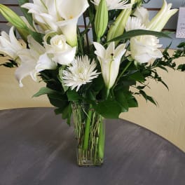 White lilies and chrysanthemums in a clear glass vase
