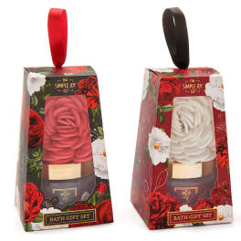 Two floral-patterned bath gift sets with rose-shaped candles in red and white boxes