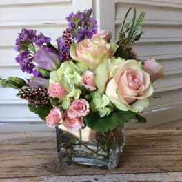 Pink and lavender roses in a clear glass vase