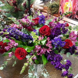 Bouquet of red roses and purple flowers in a glass vase