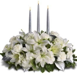White floral centerpiece with three silver taper candles