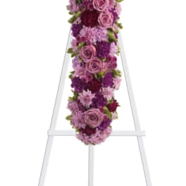 Purple and pink floral cross on a white easel
