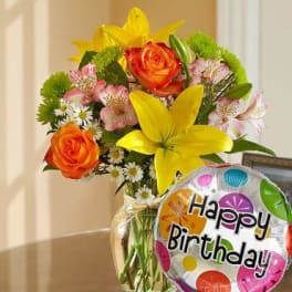Bouquet of orange roses and yellow lilies with a birthday balloon