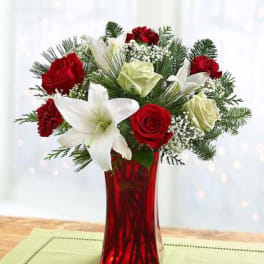 Red roses and white lilies in a red glass vase