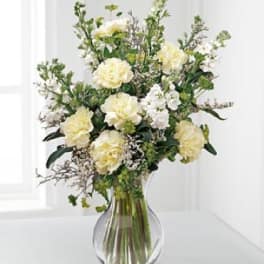 Creamy white flowers in a clear glass vase