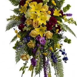 Tall standing floral spray with yellow, purple, and blue flowers
