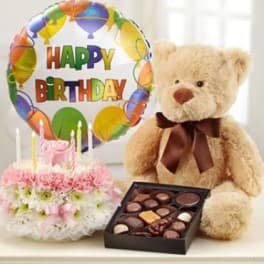 Birthday balloon, teddy bear, flowers, and chocolates arranged together