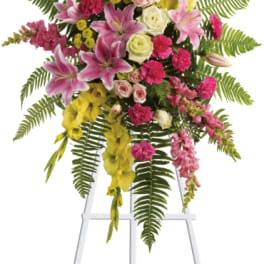 Tall floral spray with pink, yellow, and white flowers on a white easel
