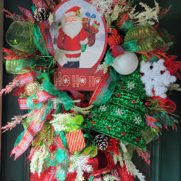 Christmas wreath with Santa sign, ribbons, pinecones, and ornaments