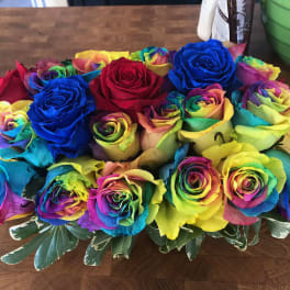 Bouquet of rainbow-colored roses with variegated greenery