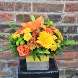Orange lilies and yellow roses in a square box arrangement