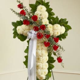Standing floral spray with red roses and white blooms on a ribboned easel