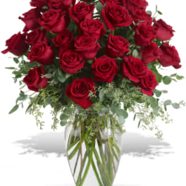 Red roses arranged in a clear glass vase