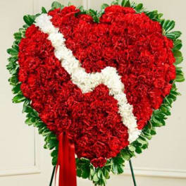 Heart-shaped red floral tribute with a white diagonal ribbon and green border