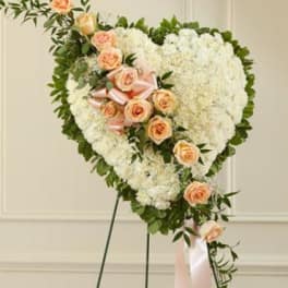 Heart-shaped floral standing spray with white blooms and peach roses