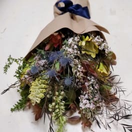 Mixed bouquet wrapped in brown paper with a navy ribbon