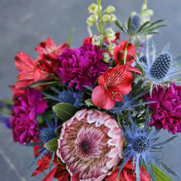 Bright mixed bouquet with magenta, red, and blue flowers