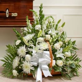 White floral basket arrangement with a large white bow