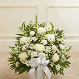 White floral arrangement with daisies and mums in a vase, tied with a white bow