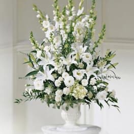 White floral arrangement in a white pedestal vase