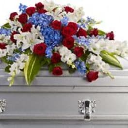 Red, white, and blue funeral spray on a silver casket