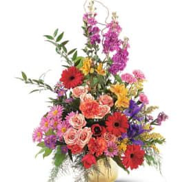Colorful mixed flower arrangement in a gold vase