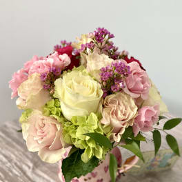 Pink and cream rose bouquet in a heart-patterned mug