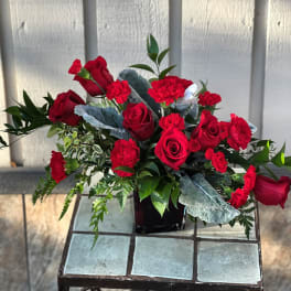 Red roses and carnations arranged in a black vase