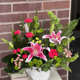 Pink lilies and carnations in a white vase