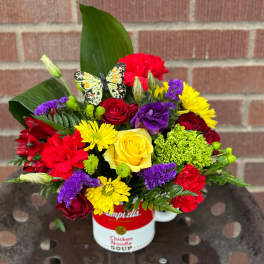 Colorful mixed bouquet in a soup can with a butterfly decoration