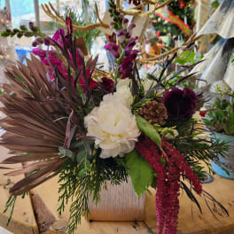 Mixed floral arrangement with white and deep purple blooms in a square vase