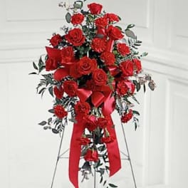 Tall red rose standing spray with a red ribbon on a metal easel